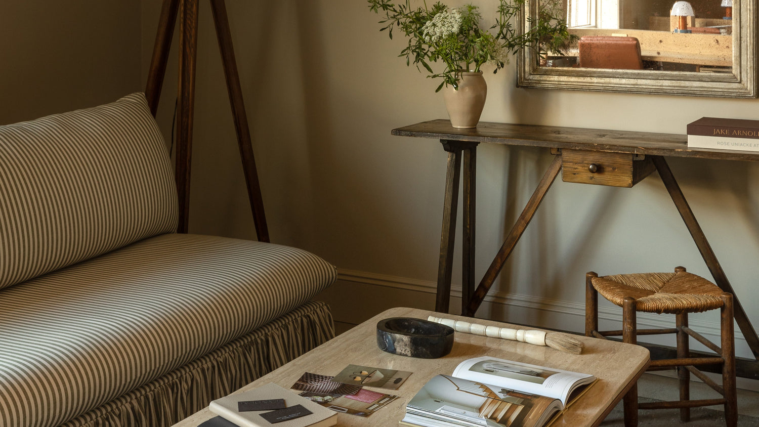 Sitting area with a couch, coffee table, lamp, and mirror.